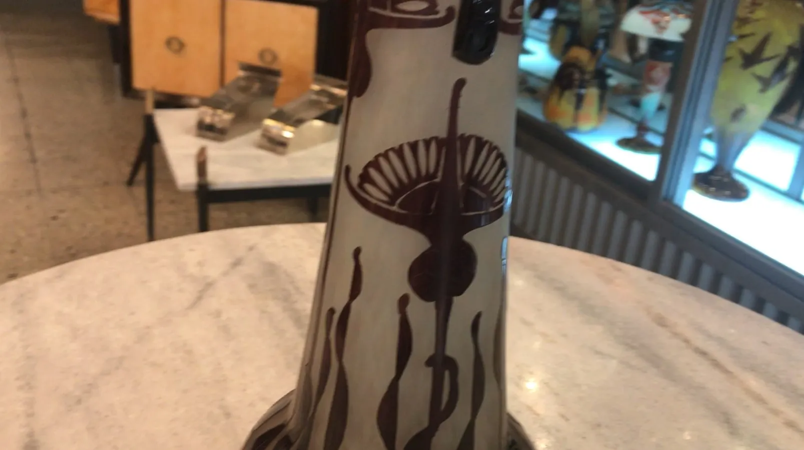 Подписанное стекло Le Verre с элегантным темным декором, фон антикварной лавки.