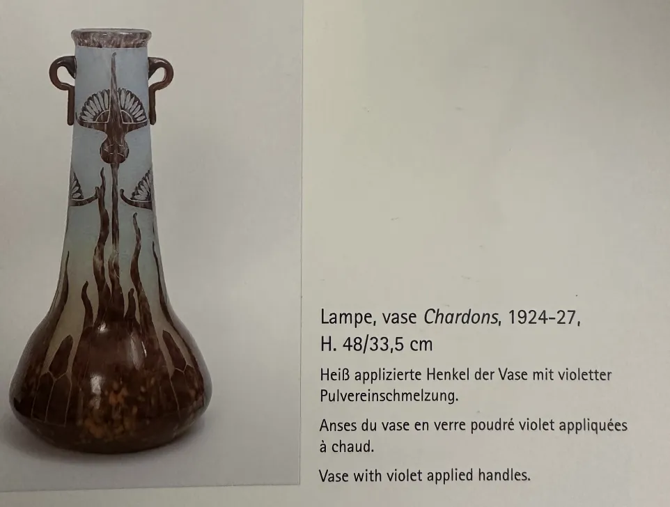 Vase ancien en verre avec motif décoratif et anses.