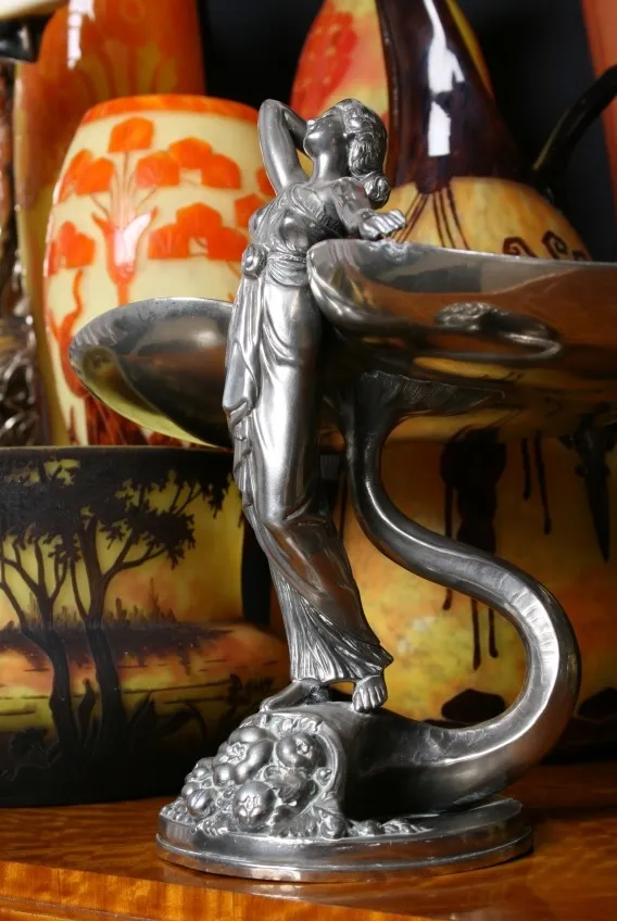 Figura antigua con elegante diseño en vidrio firmado, fondo colorido.