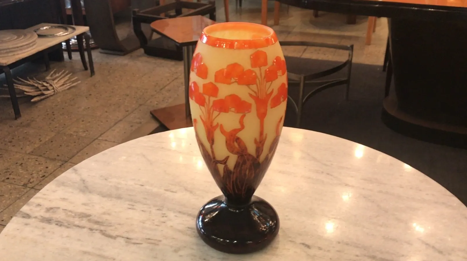 Antiker Vase mit warmer floraler Dekoration.