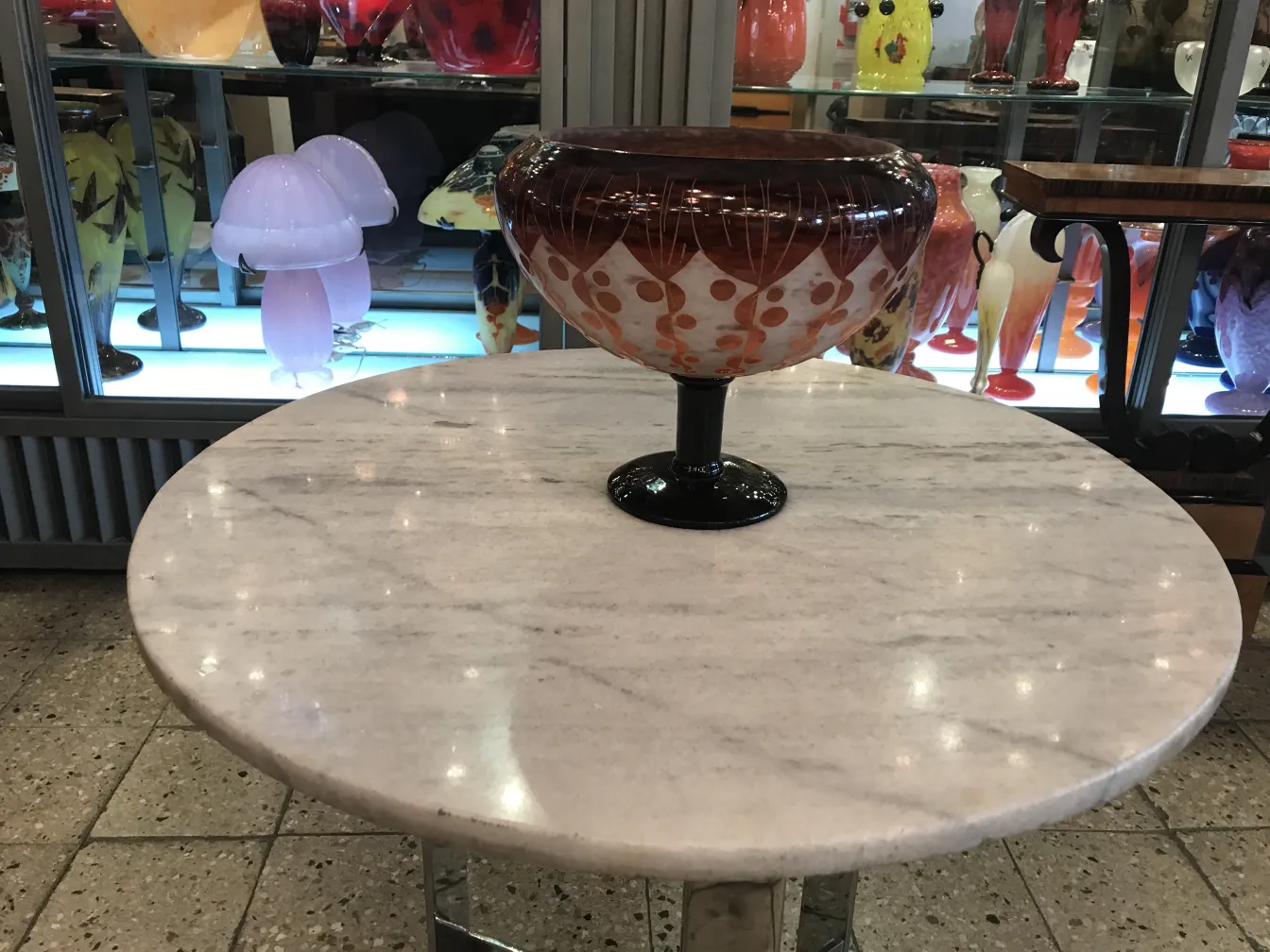 peça de vidro antigo assinado Le Verre em uma mesa