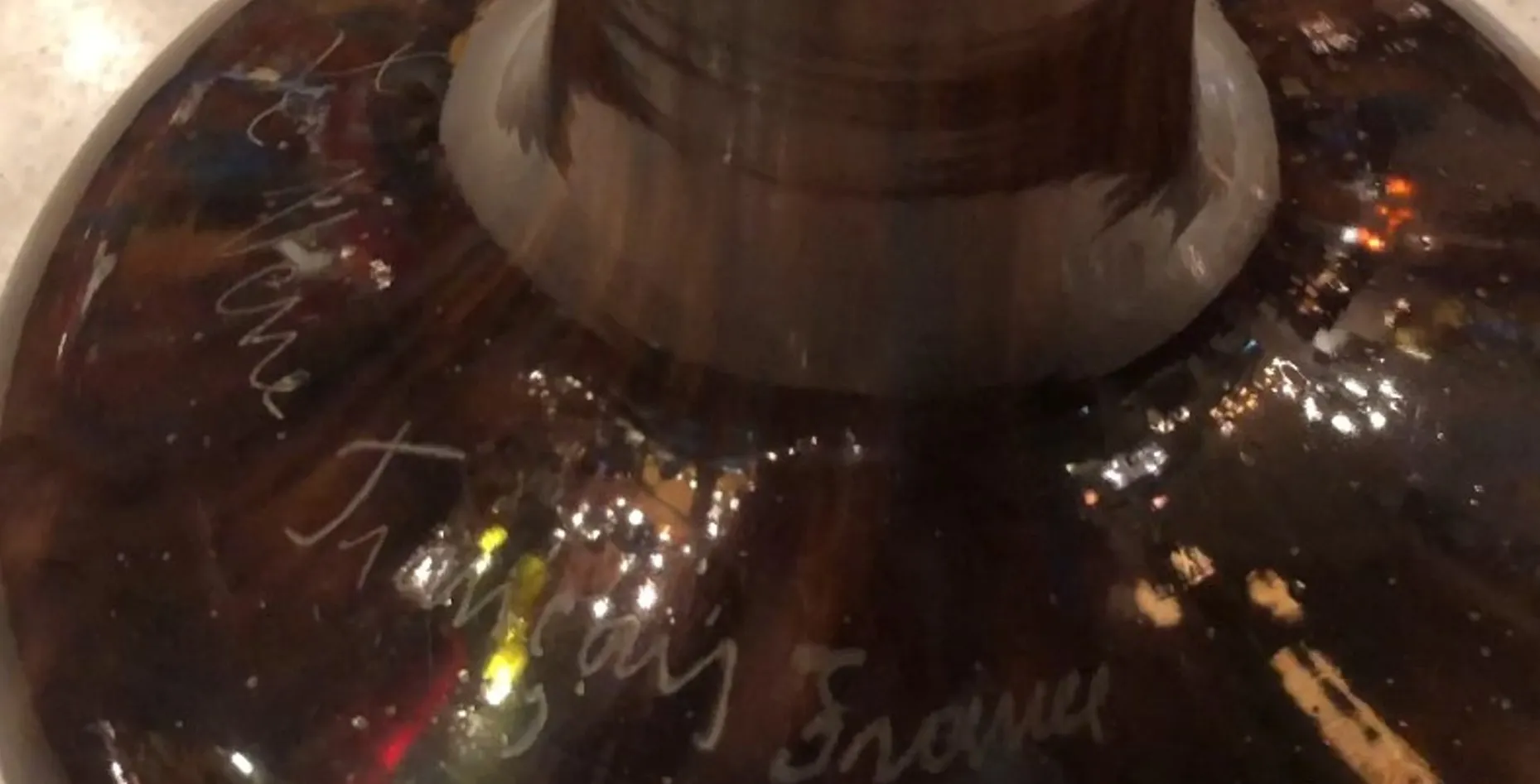 Antikes signiertes Glas mit komplexen Details, dunkler Hintergrund.