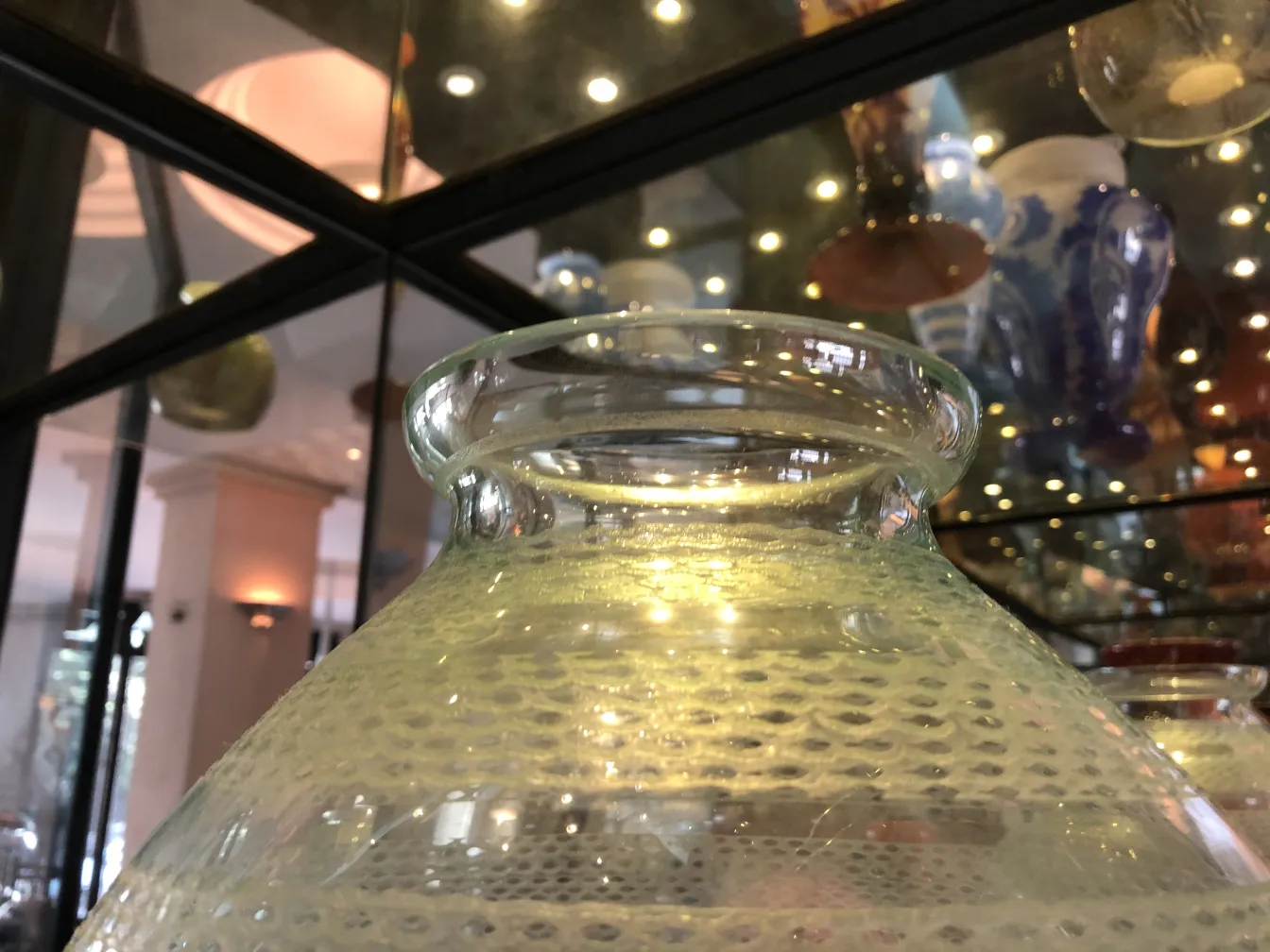 Vetro firmato Daum Nancy, antiquariato con design distintivo e lucentezza. Sfondo di vetrine illuminate.