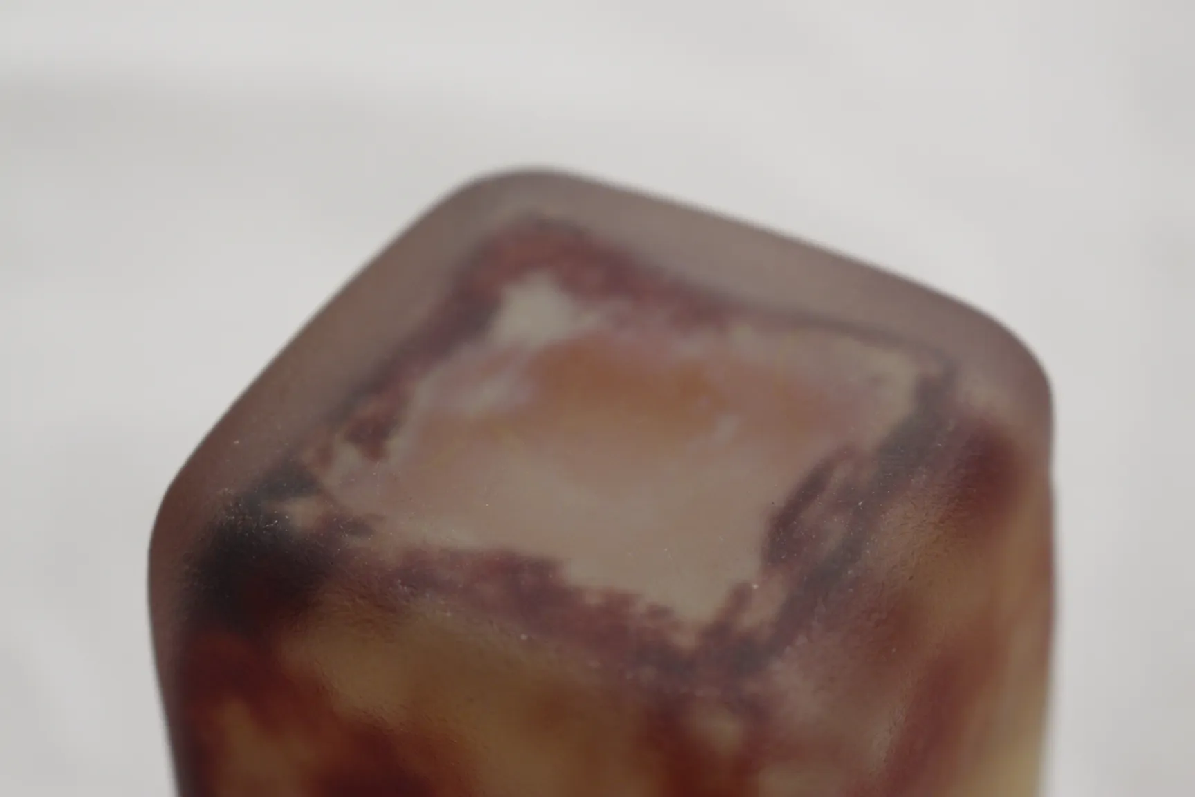 Antique signed glass Daum Nancy in brown and beige tones against a white background.