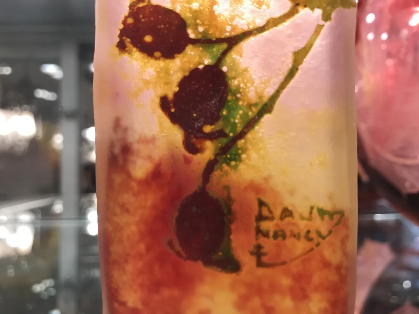 Vetro firmato Daum Nancy con decorazioni floreali in toni caldi, atmosfera antica.