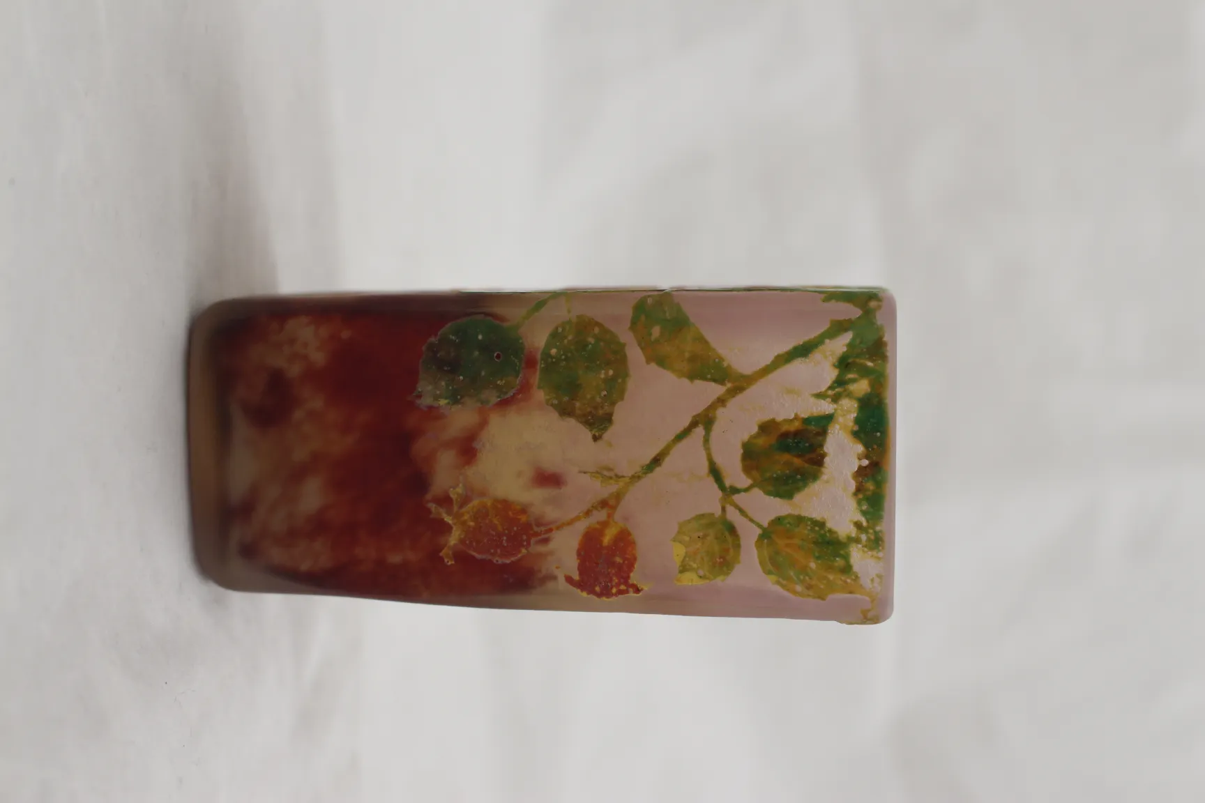 Verre ancien signé daum nancy décoré de feuilles vertes et rouges, fond clair.