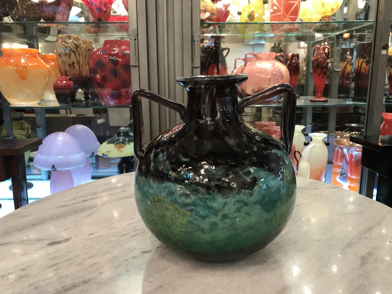 Vaso antico firmato Daum Nancy con colori vivaci in un ambiente d'antiquariato.