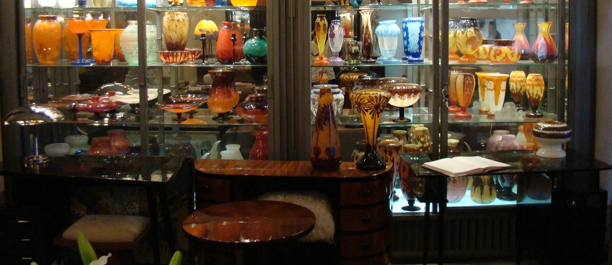 Vidrio antiguo firmado Daum Nancy en vitrina con otros objetos decorativos.