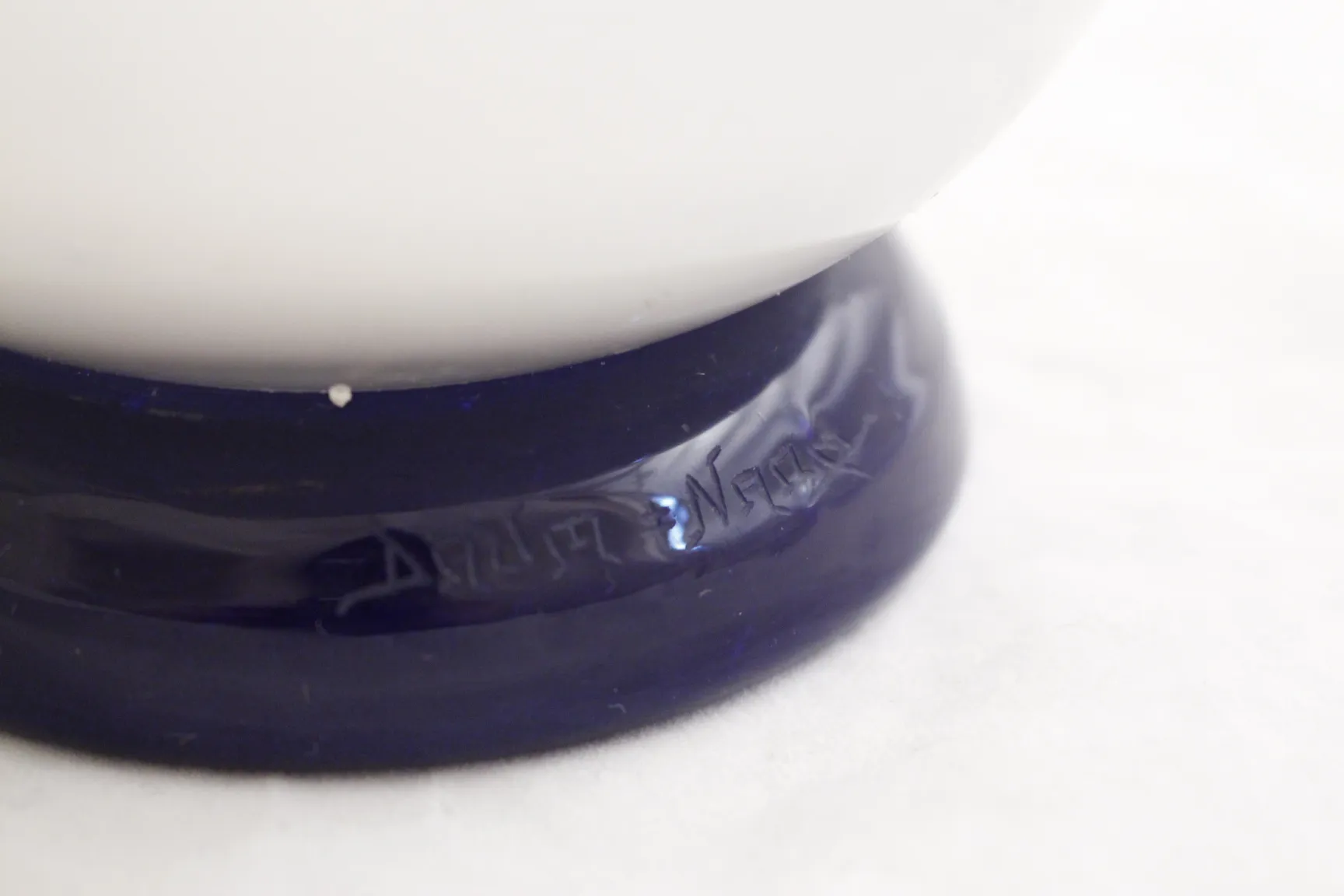 Vidro assinado Daum Nancy com base azul e detalhes brancos.