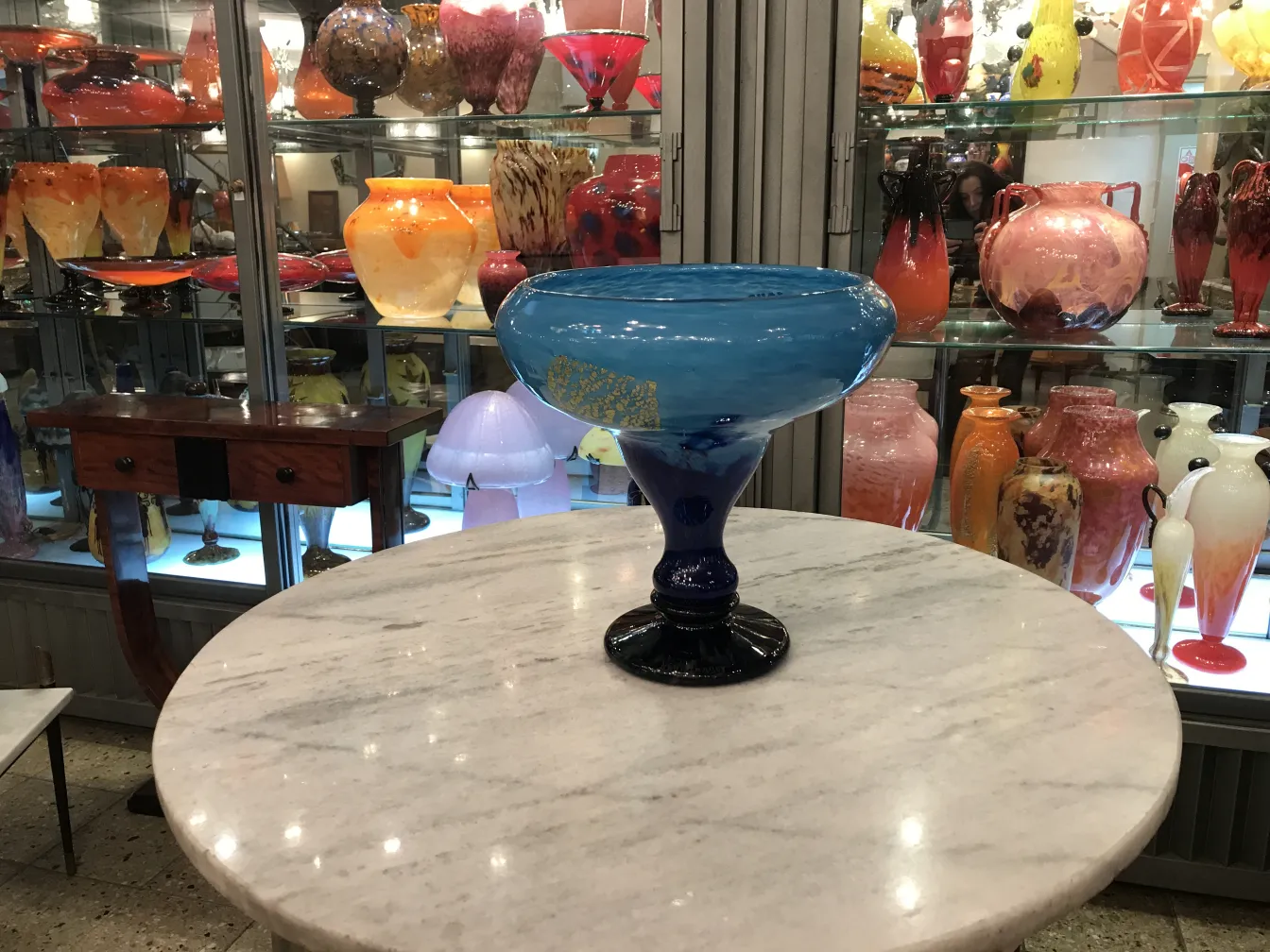 bowl de vidrio azul con base negra sobre mesa de mármol