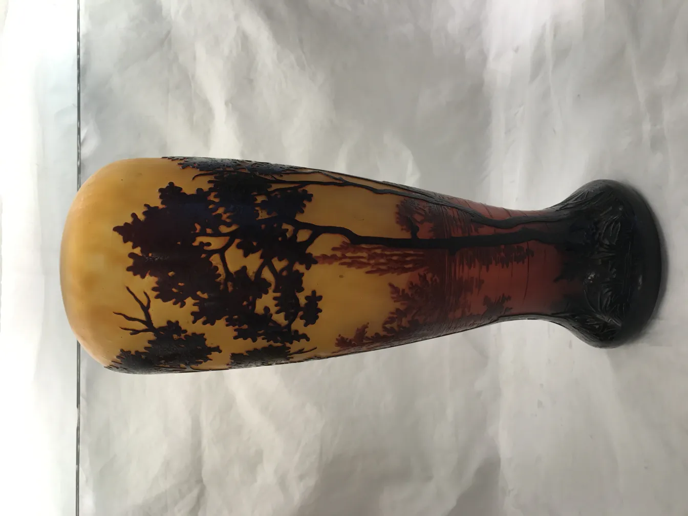 Antique glass featuring a landscape in orange and black hues.