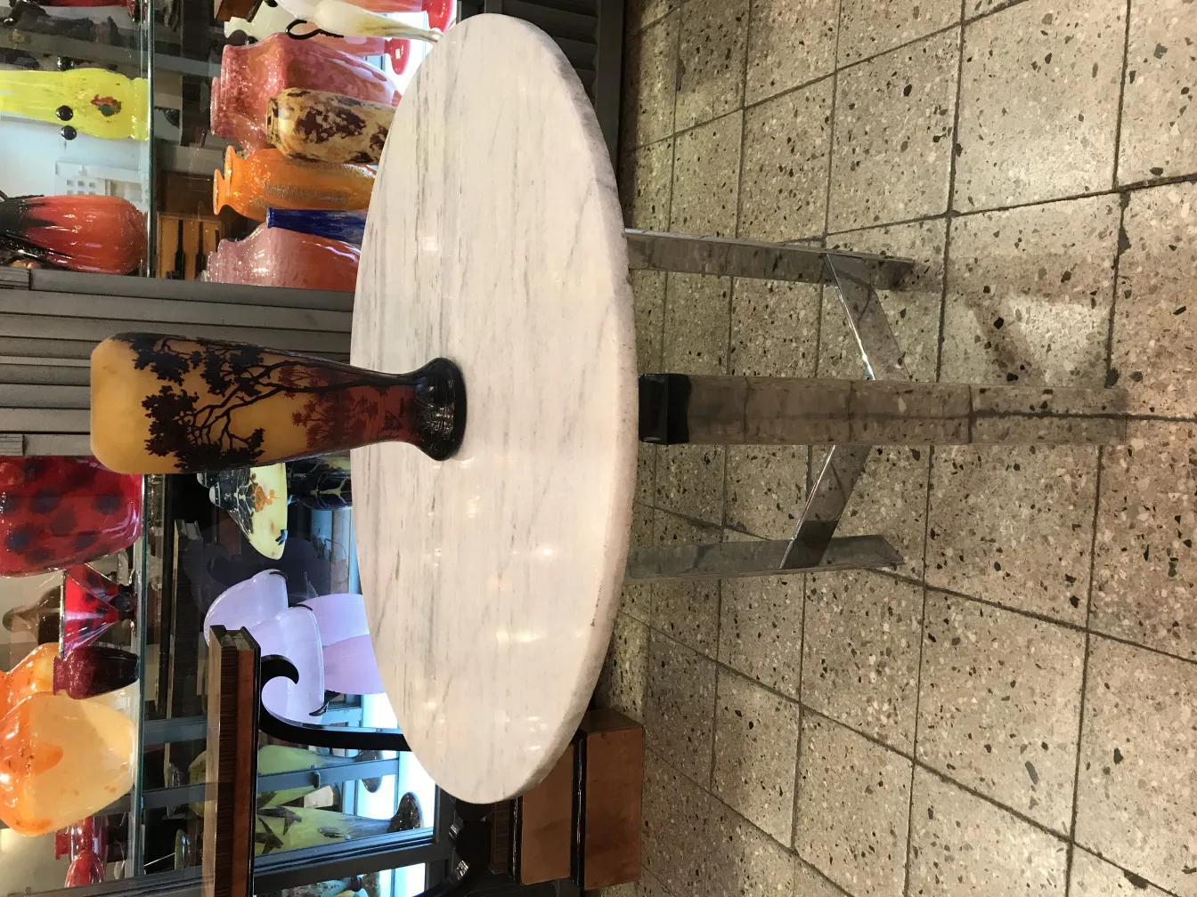 Antiquité vase en verre avec signature visible de Daum Nancy. Base noire et fond décoratif.