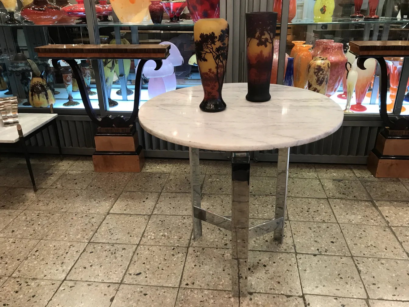 Vidro assinado Daum Nancy em um ambiente de antiguidades decorativas com outros objetos.