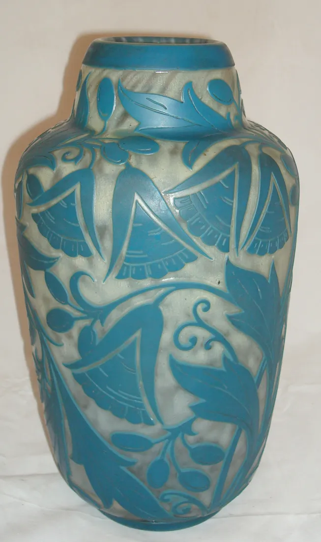 Vase décoratif en verre signé Daum Nancy avec des motifs floraux bleus.