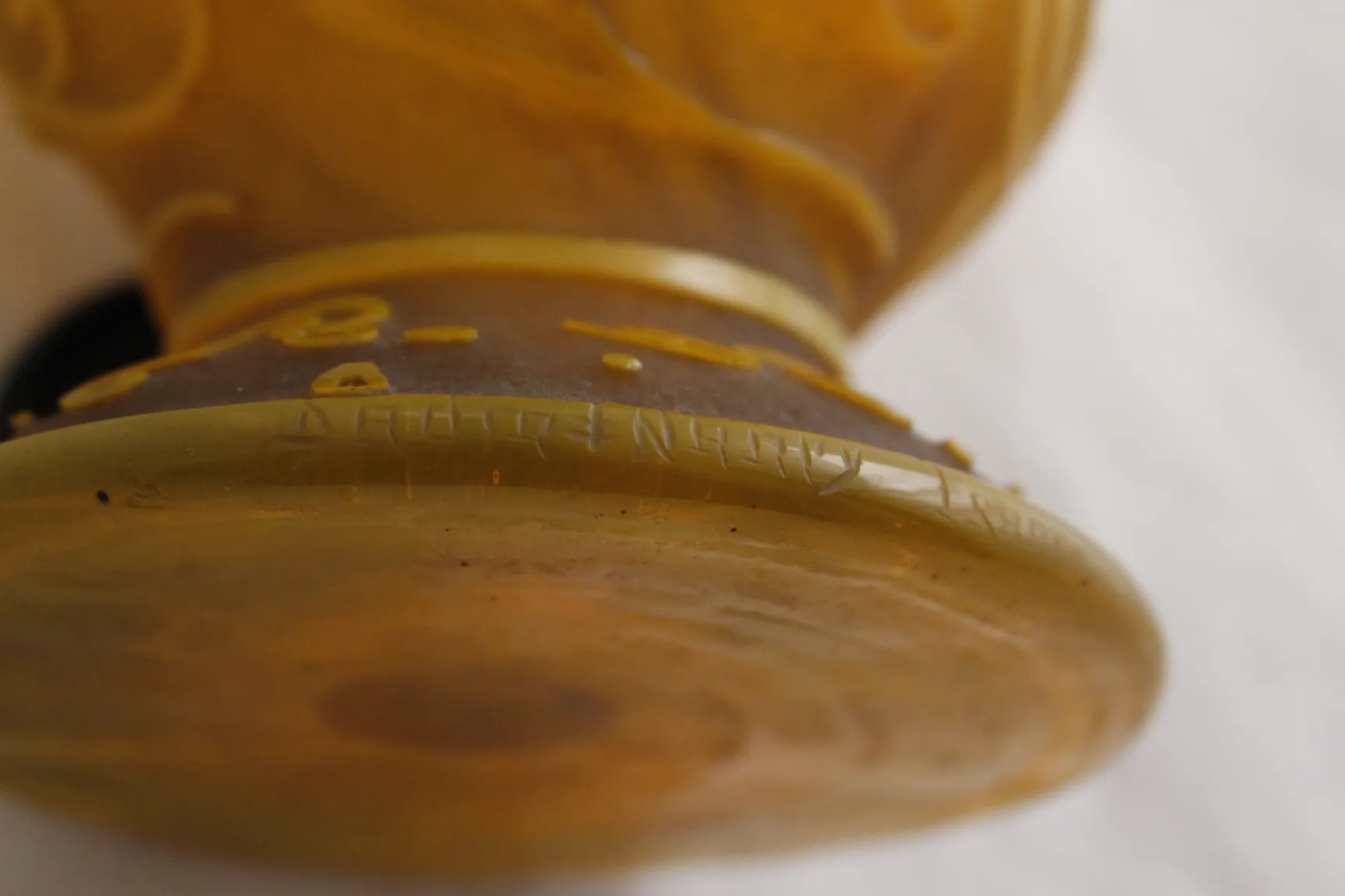 Signiertes Glas Daum Nancy mit gewellten Details in einer neutralen Umgebung.