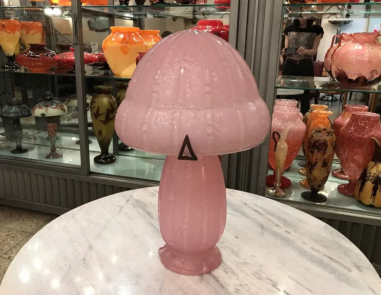 Lampe en verre rose en forme de champignon avec des détails.
