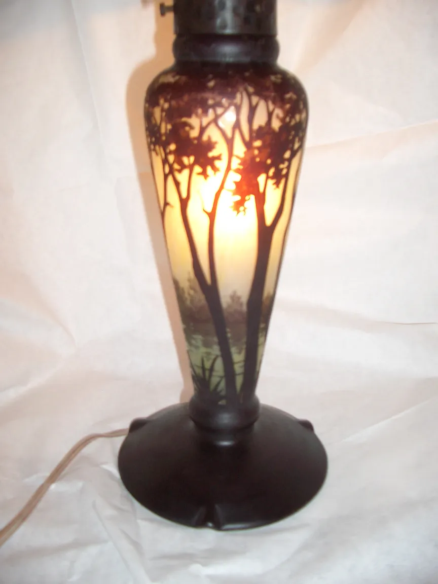 Antique lamp with tree design softly illuminating.