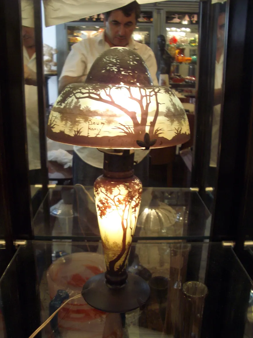 Lâmpada antiga com vidro assinado Daum Nancy, detalhes de árvores, luz quente.