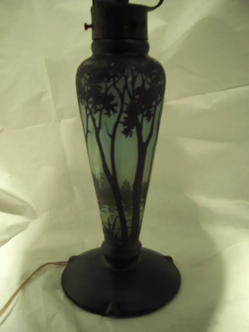 Lampe en verre avec des arbres à l'arrière-plan, ambiance chaleureuse.