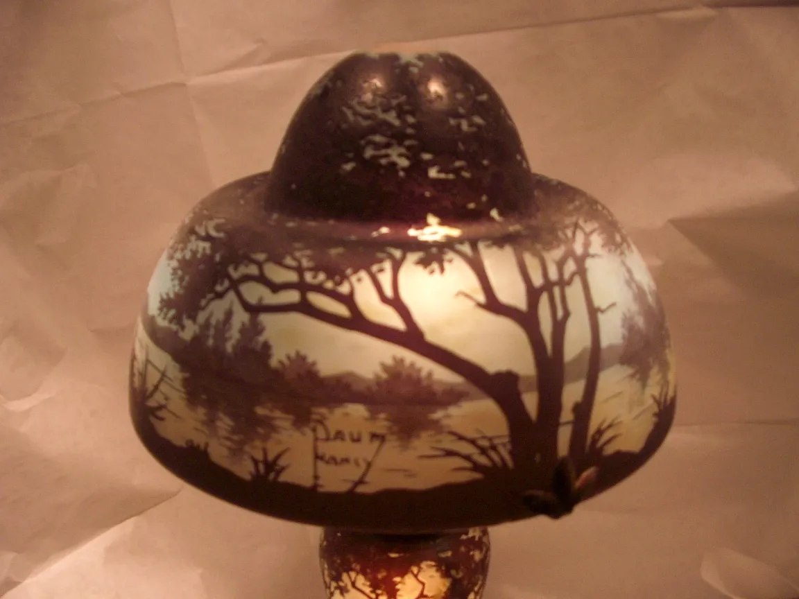 Lampada in vetro antico con paesaggio naturale e design notevole.