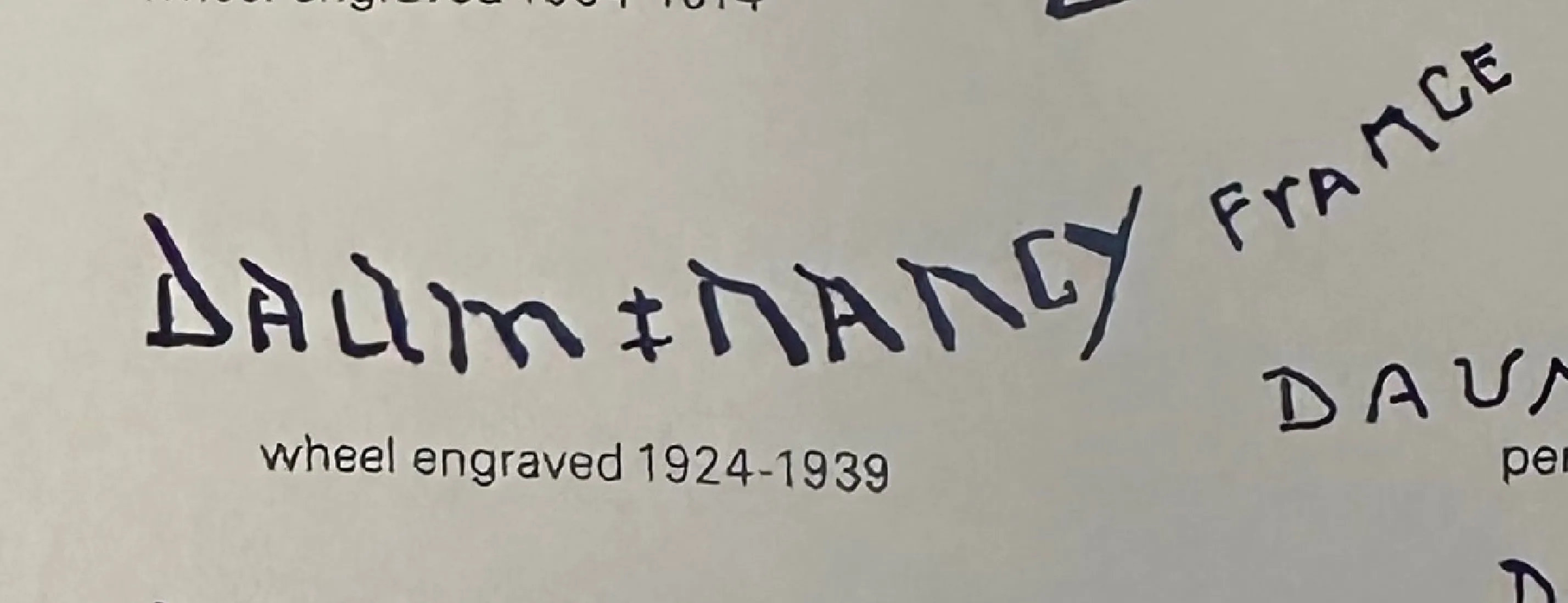 Vidrio antiguo firmado Daum Nancy con detalles visibles, entorno clásico.