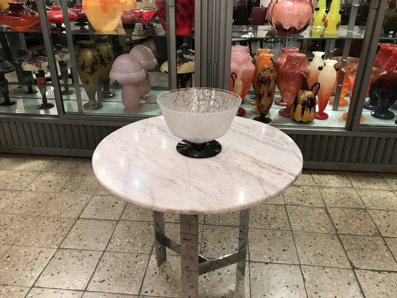 glas schüssel signiert von daum nancy auf einem marmortisch, bunte dekoration im hintergrund