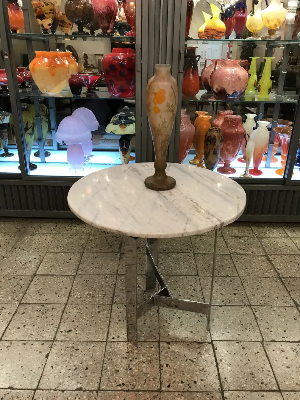 Vase ancien signé Daum Nancy exposé avec d'autres objets