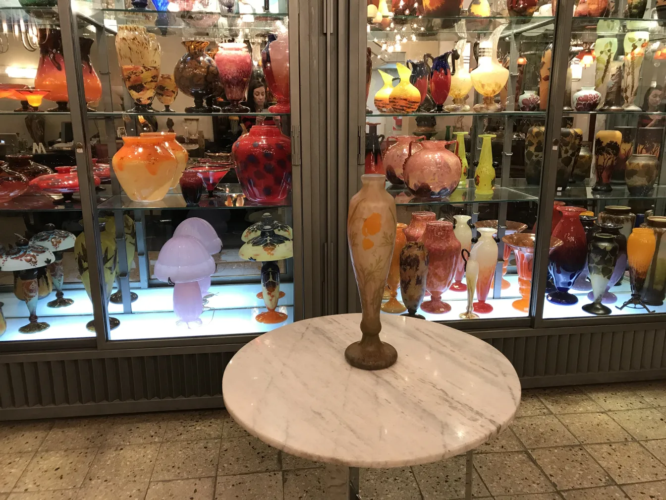 Vetro firmato Daum Nancy esposto in un ambiente colorato di antiquariato.