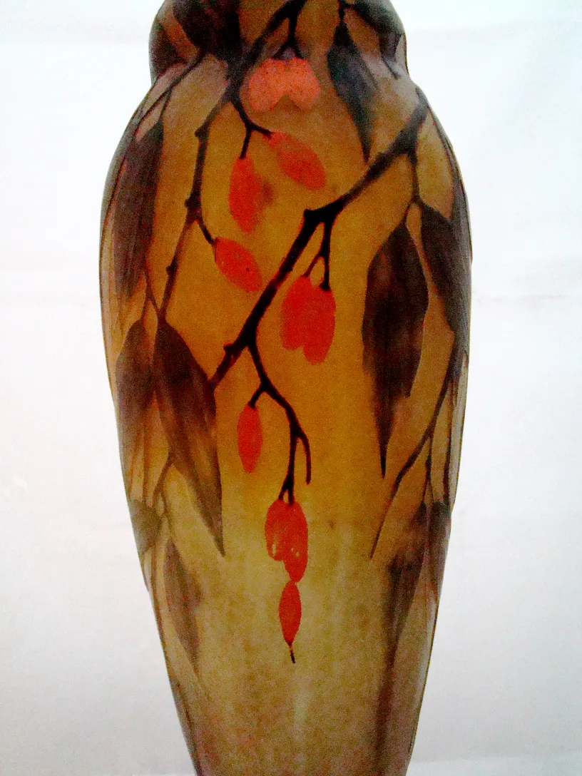 Decorative glass vase signed Daum Nancy featuring leaves and red fruits.