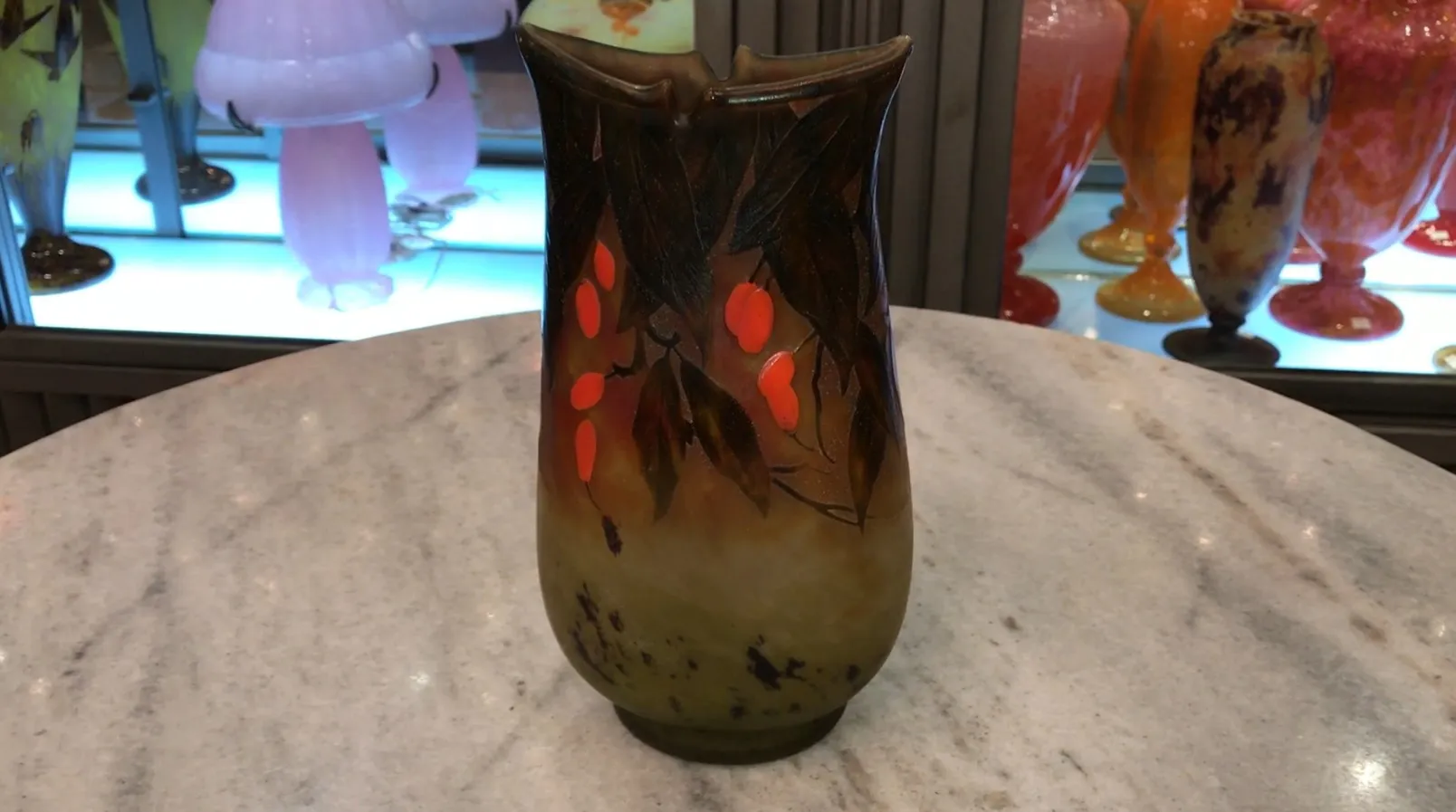 Vidro assinado decorativo Daum Nancy com folhas e frutos vermelhos em um ambiente elegante.