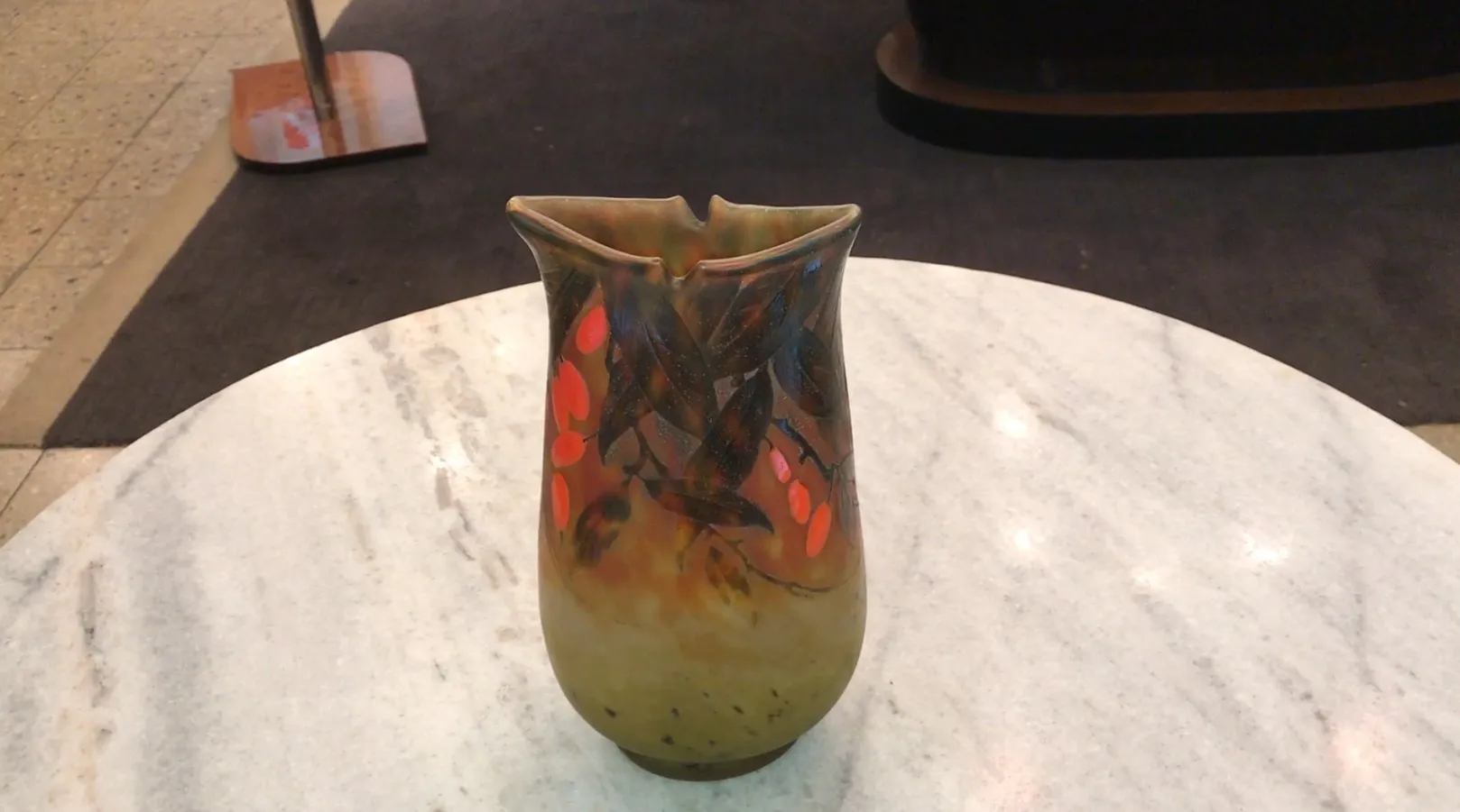 Antique glass vase with signature, decorated with leaves and red flowers, soft background