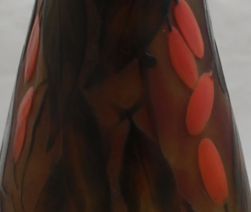 Verre ancien avec des couleurs sombres et des accents rouges, rappelant le style de Daum Nancy.