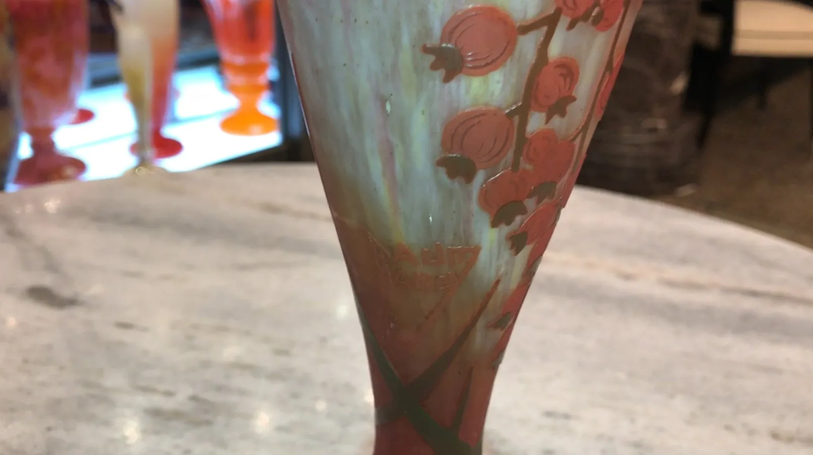 Signiertes Glas von Daum Nancy mit floraler Dekoration in warmen Tönen.