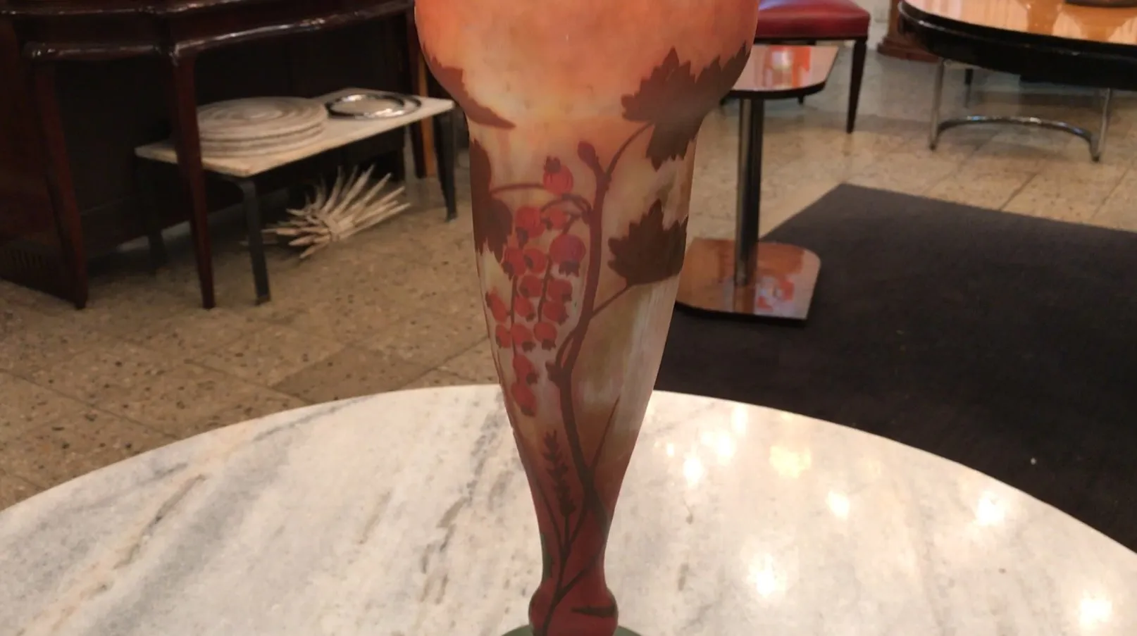 ancien vase en verre signé daum nancy avec décorations florales, exposé sur une table en marbre.