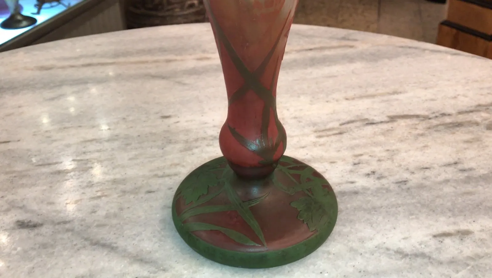 Signed glass Daum Nancy with red and green design on base, elegant setting.