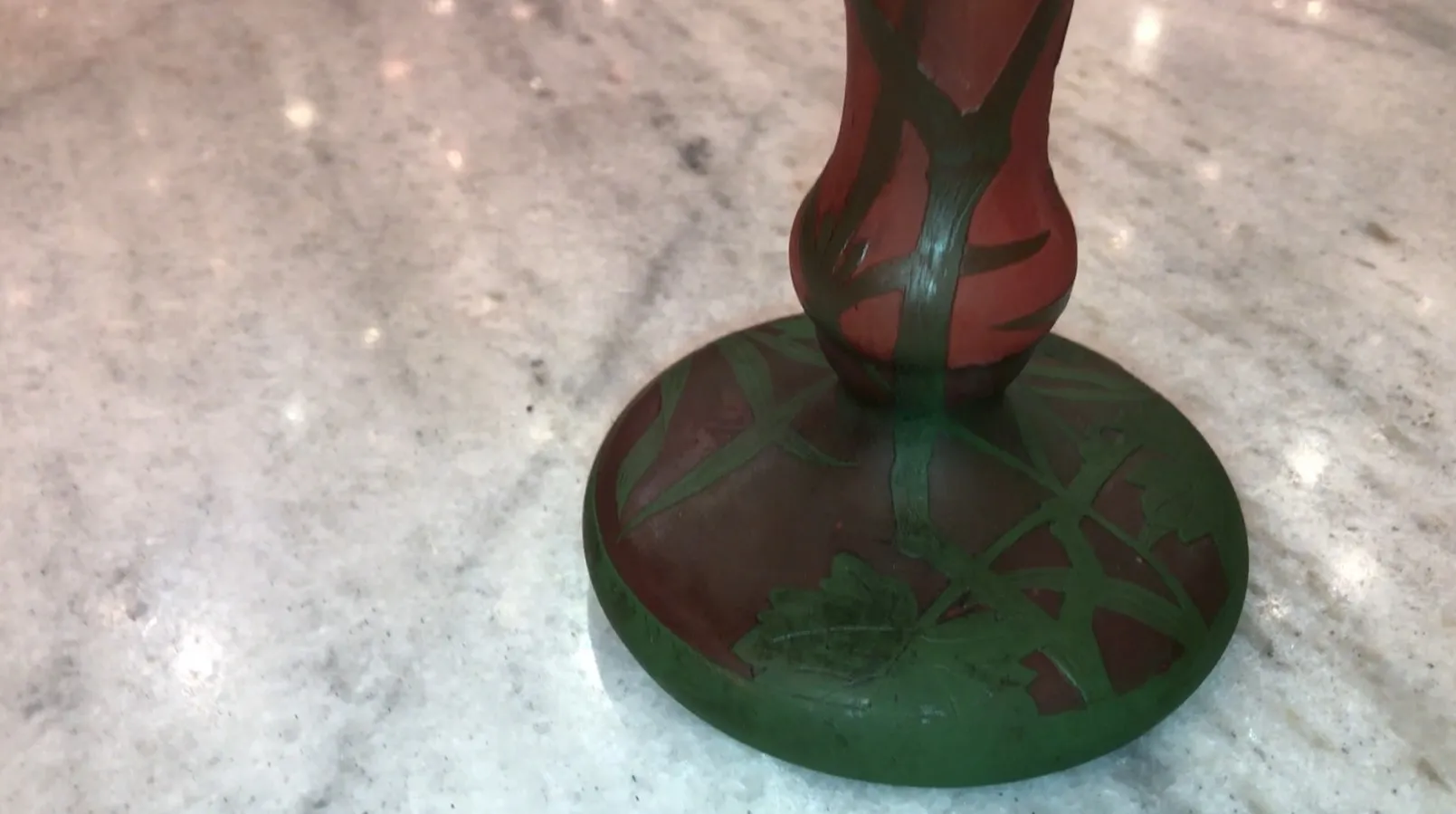 서명된 유리잔 다움 난시, 빨간색과 녹색 꽃 디자인, 대리석 배경에.