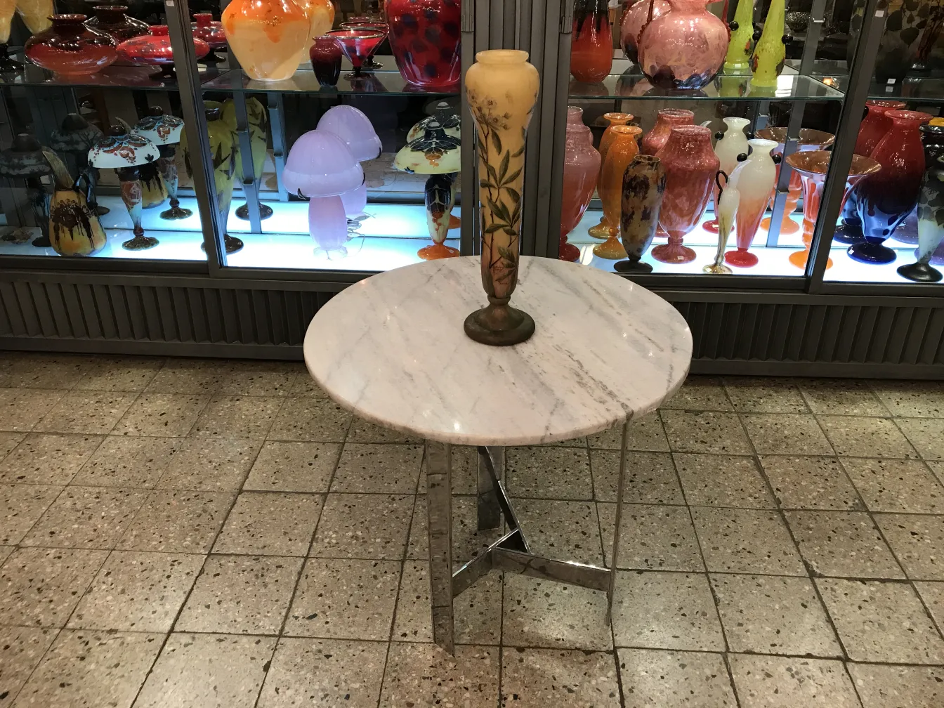 Vetro firmato antico daum nancy su un tavolo decorativo, con vasi colorati sullo sfondo.