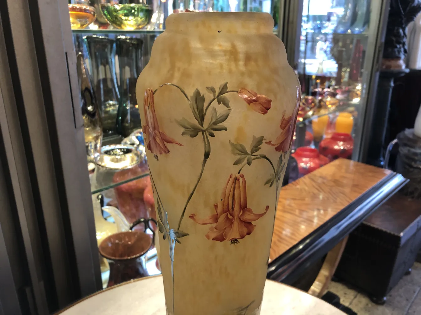 Vase aus signiertem Glas Daum Nancy mit Blumen auf gelbem Hintergrund.