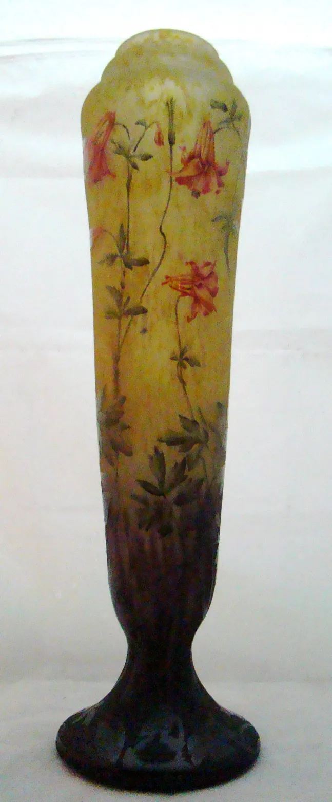 An antique signed glass by Daum Nancy showcasing floral patterns in a decorative setting.