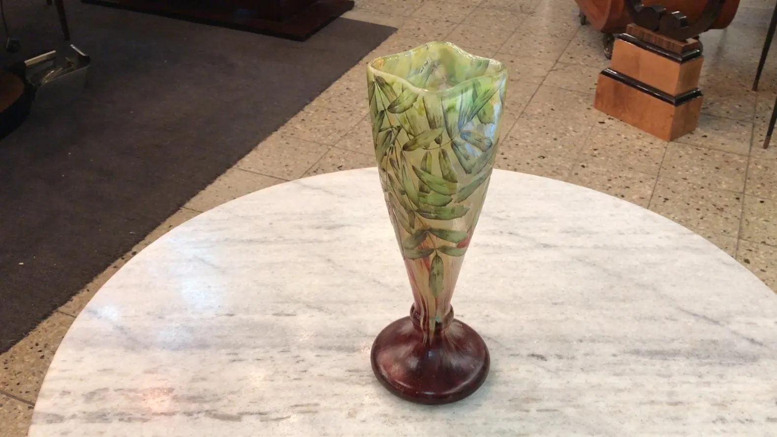 Signed glass Daum Nancy with decorative design in shades of green and pink on a rounded base.