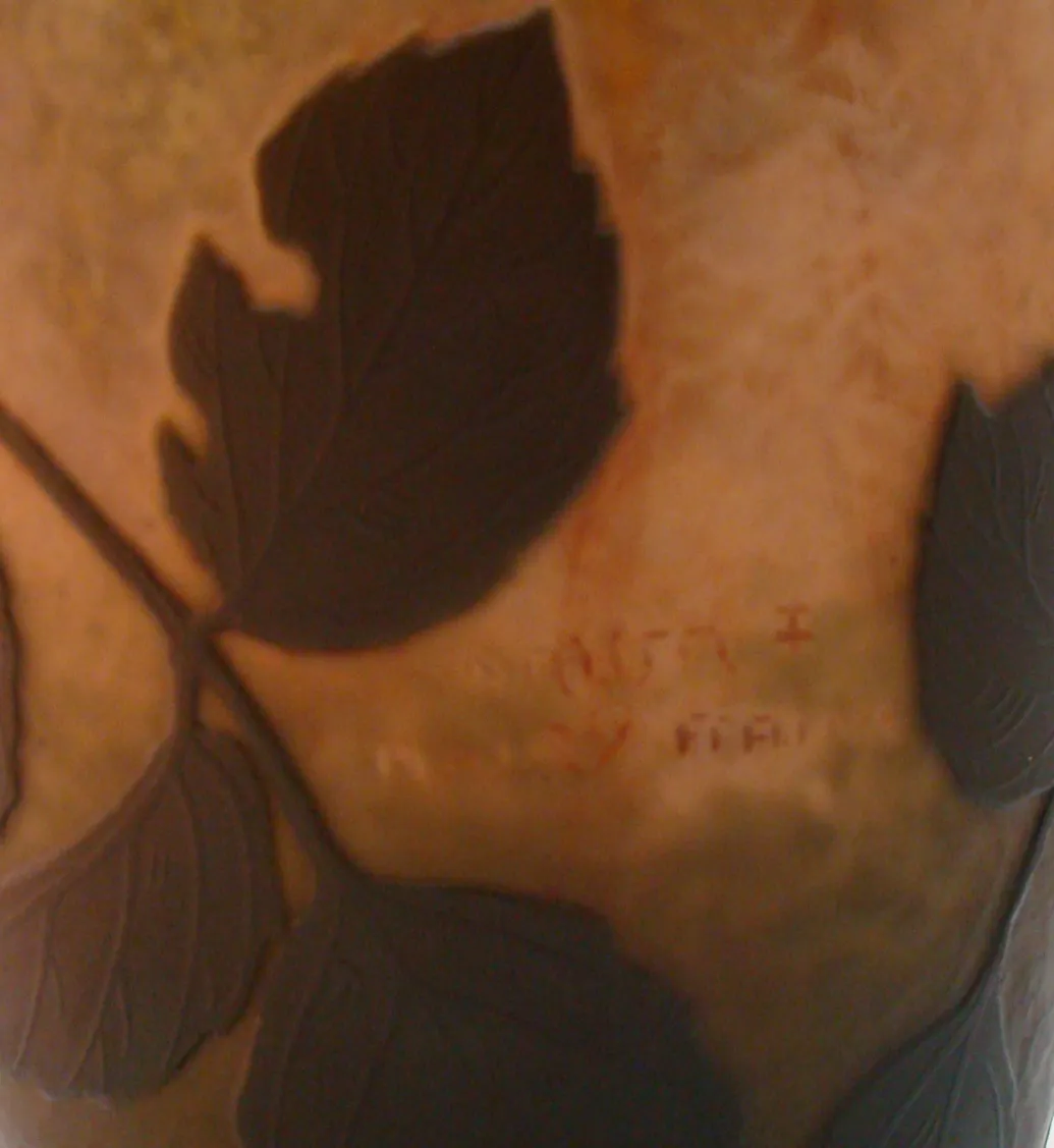 Signed Daum Nancy glass with decorative leaves, soft background