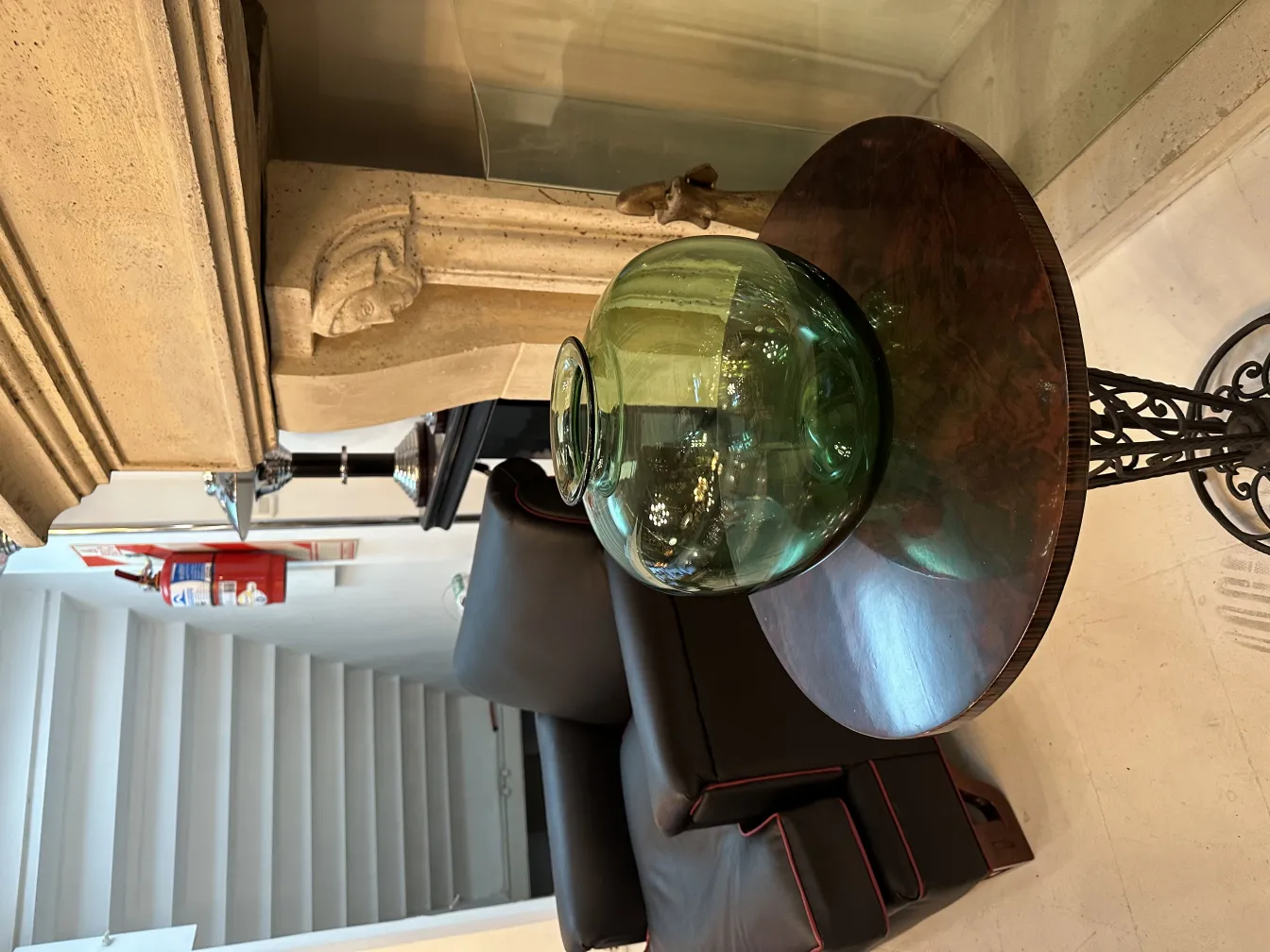 Vase en verre vert avec signature, ambiance élégante et chaleureuse.