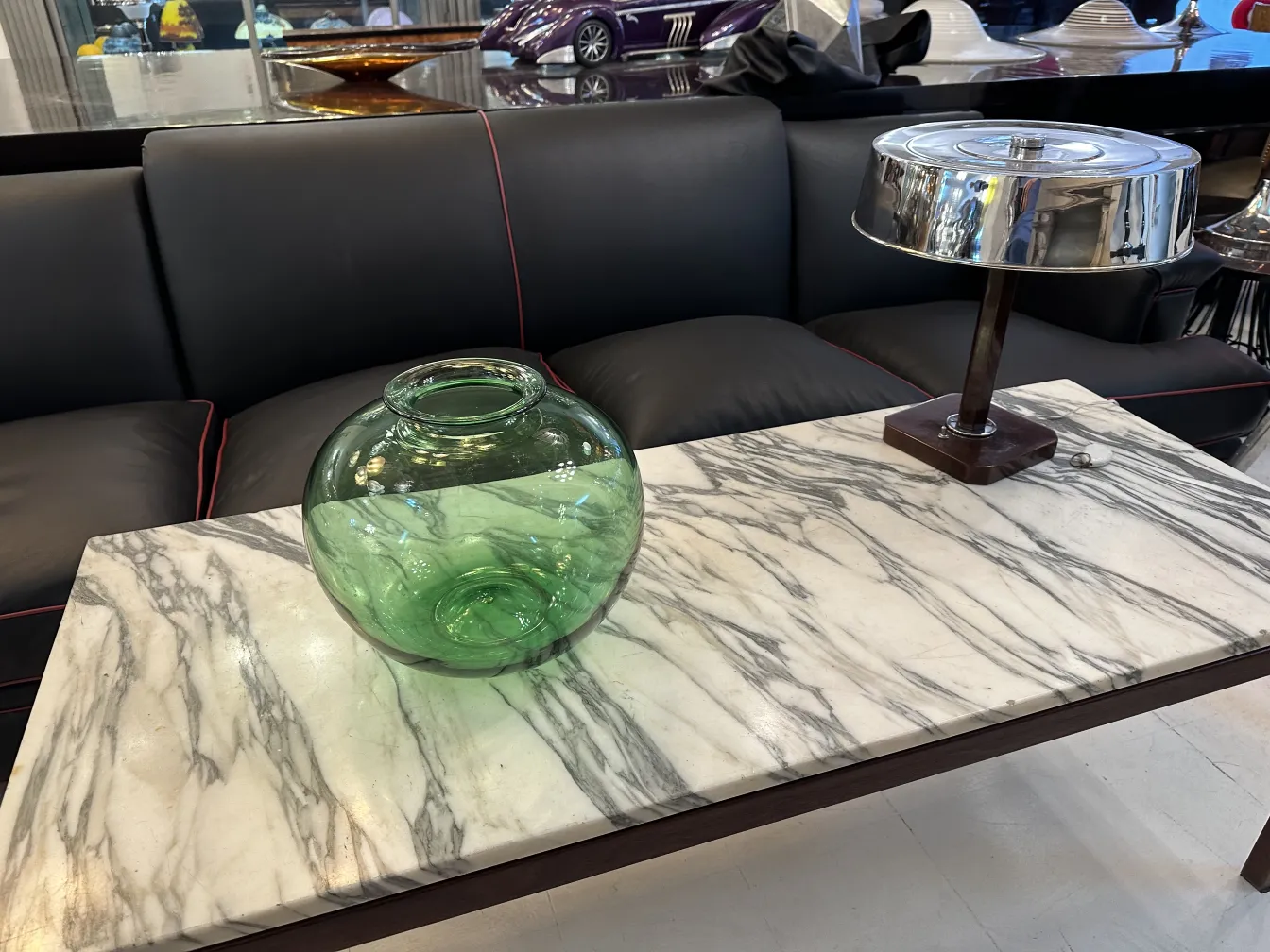 Green round glass vase in an antique setting.