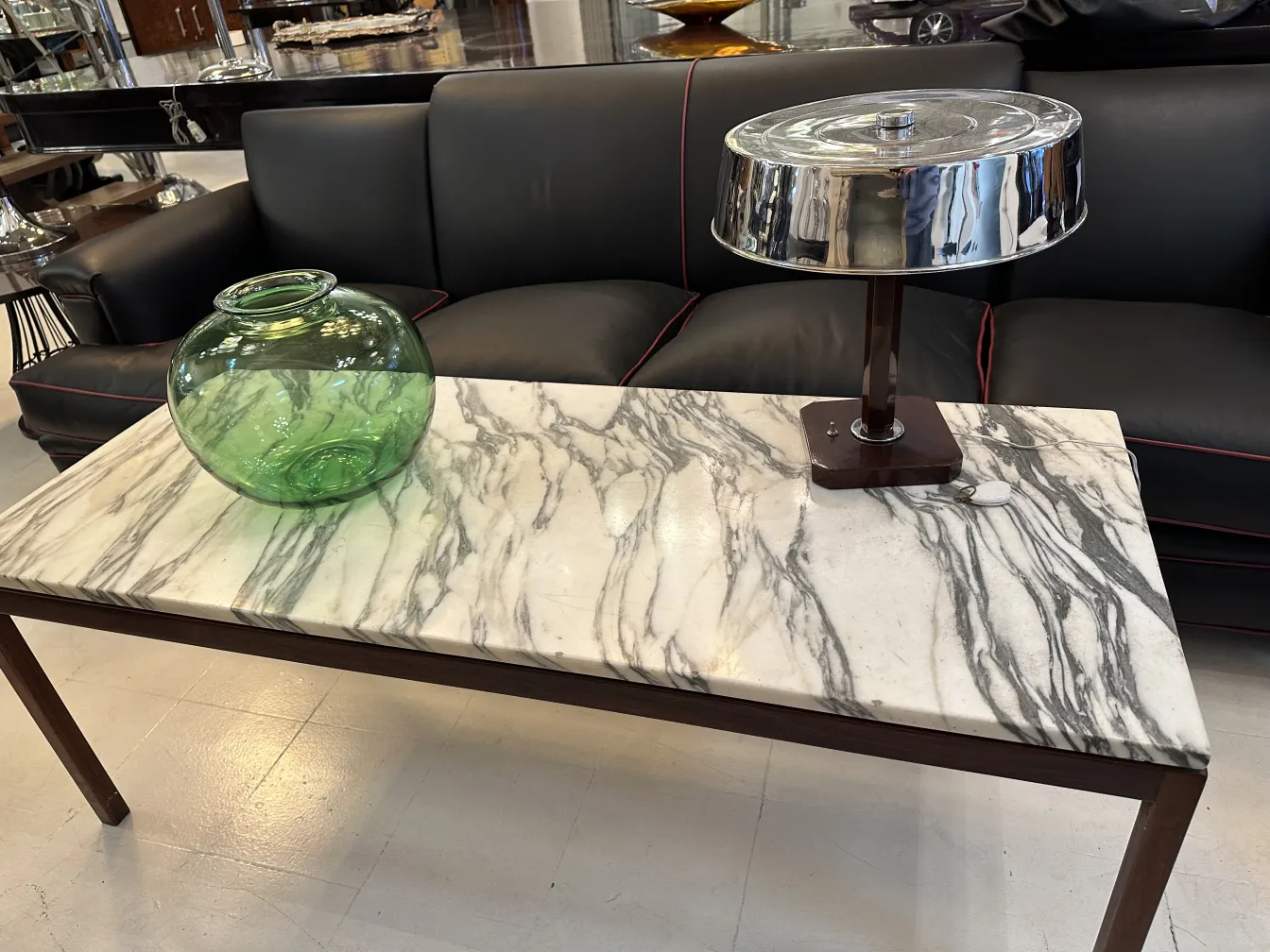 green jar and lamp on marble table