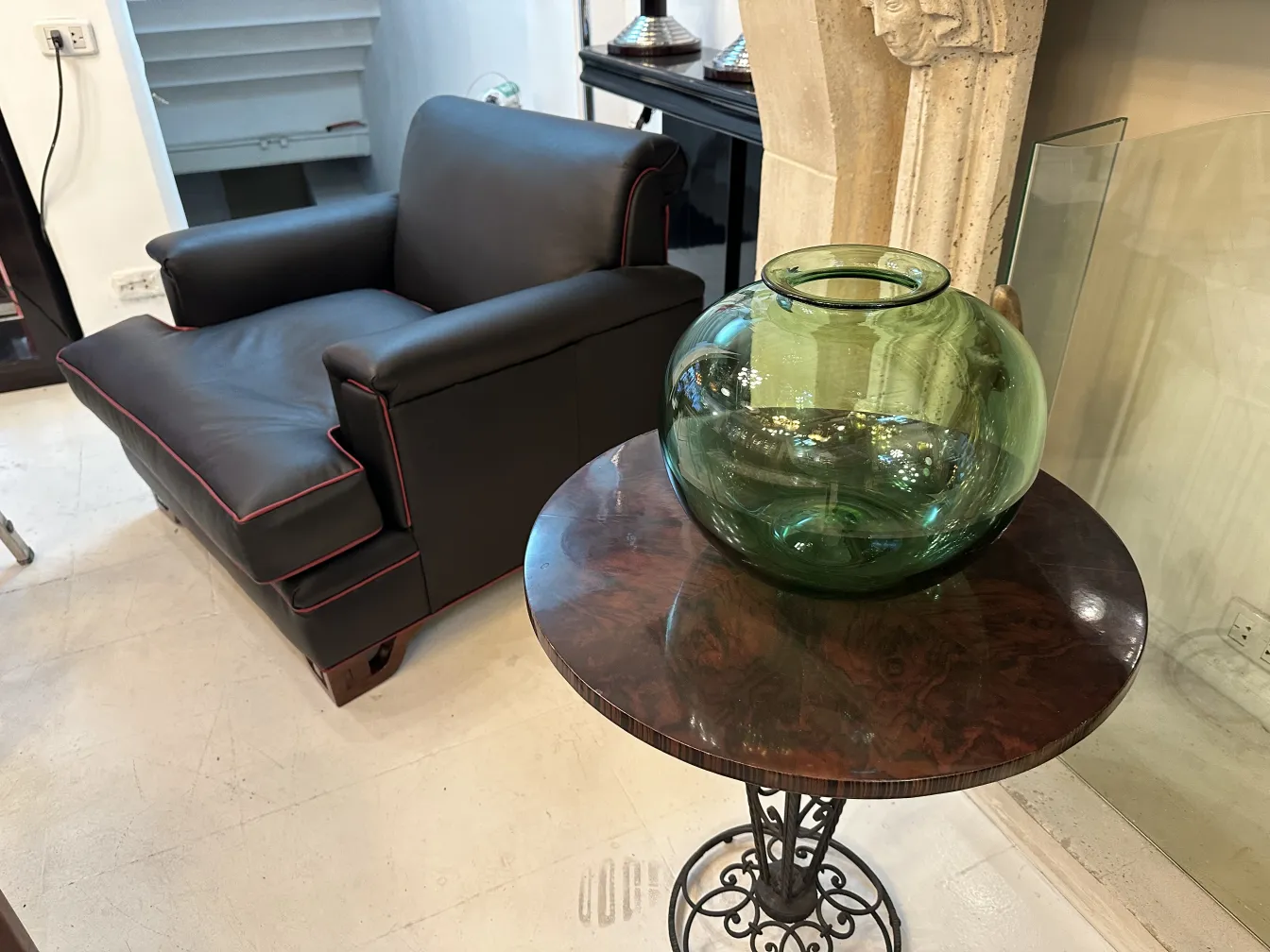 verre rond vert sur table en bois dans un cadre moderne, canapé noir derrière