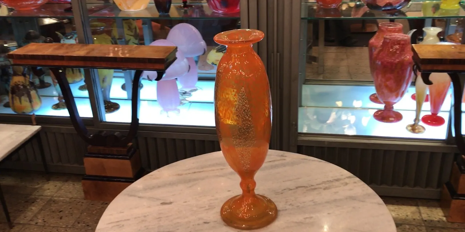 Elegantes signiertes Glas mit filigranem Design, präsentiert vor hellen Hintergrund.