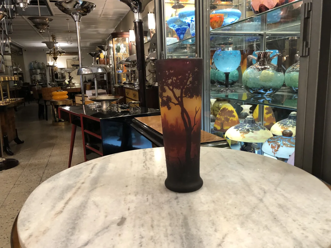 Vaso antiguo firmado de Daum Nancy en fondo de tienda de antigüedades.