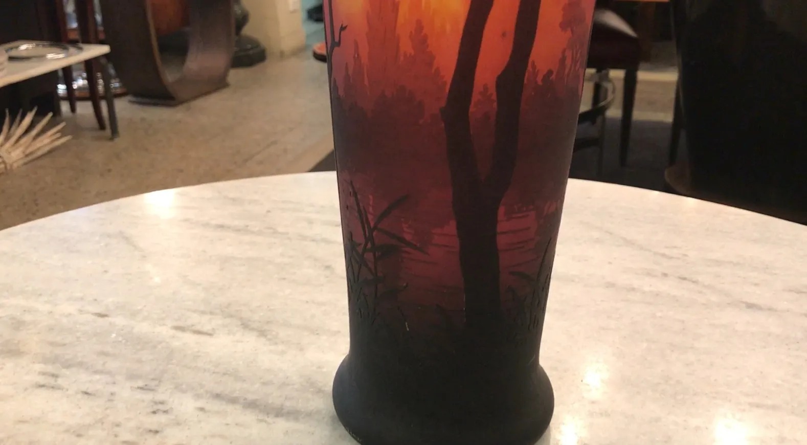 glass with signature featuring reddish and dark landscape