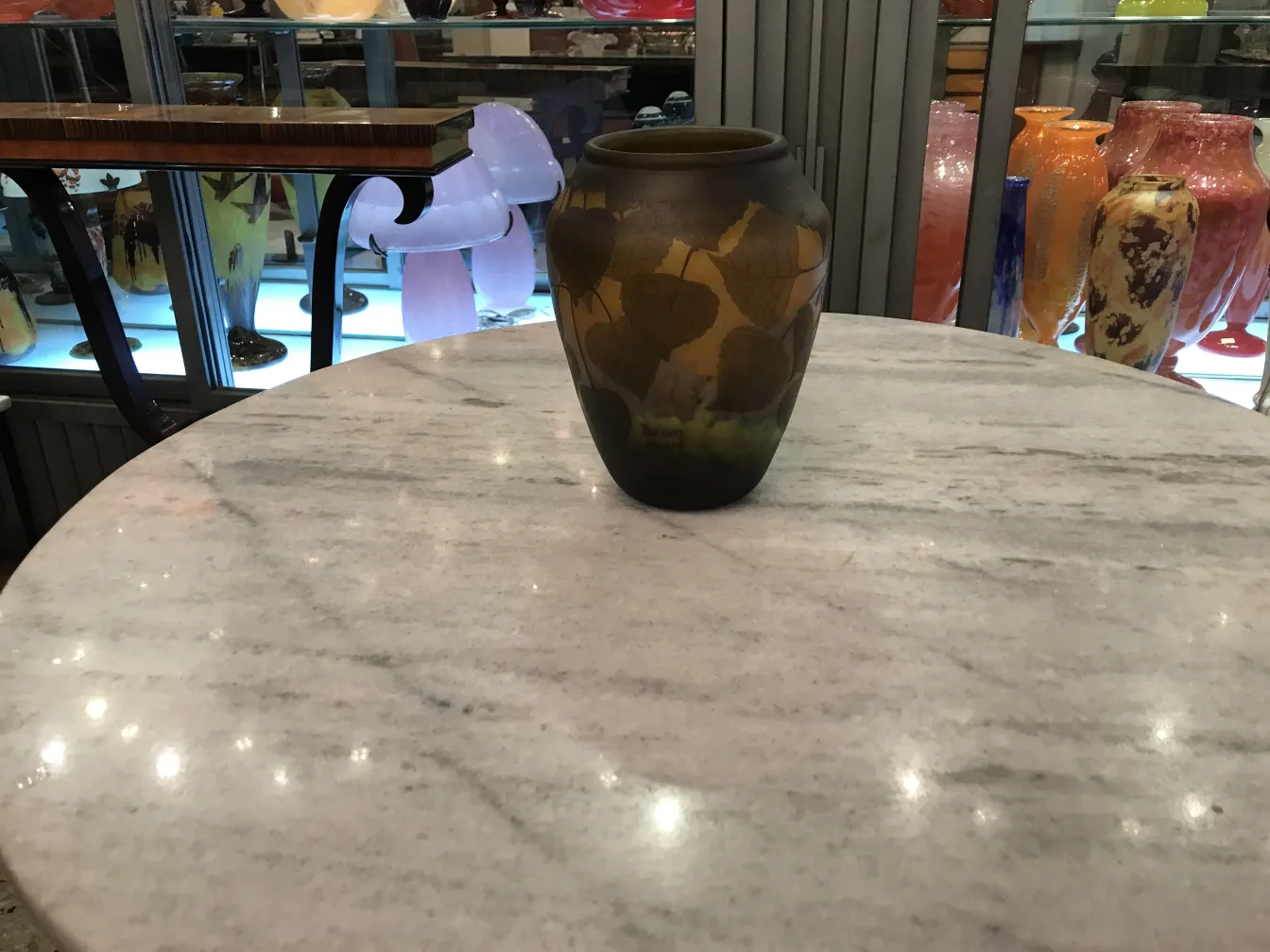 Vidro assinado Daum Nancy com decoração de folhas em um ambiente antigo.