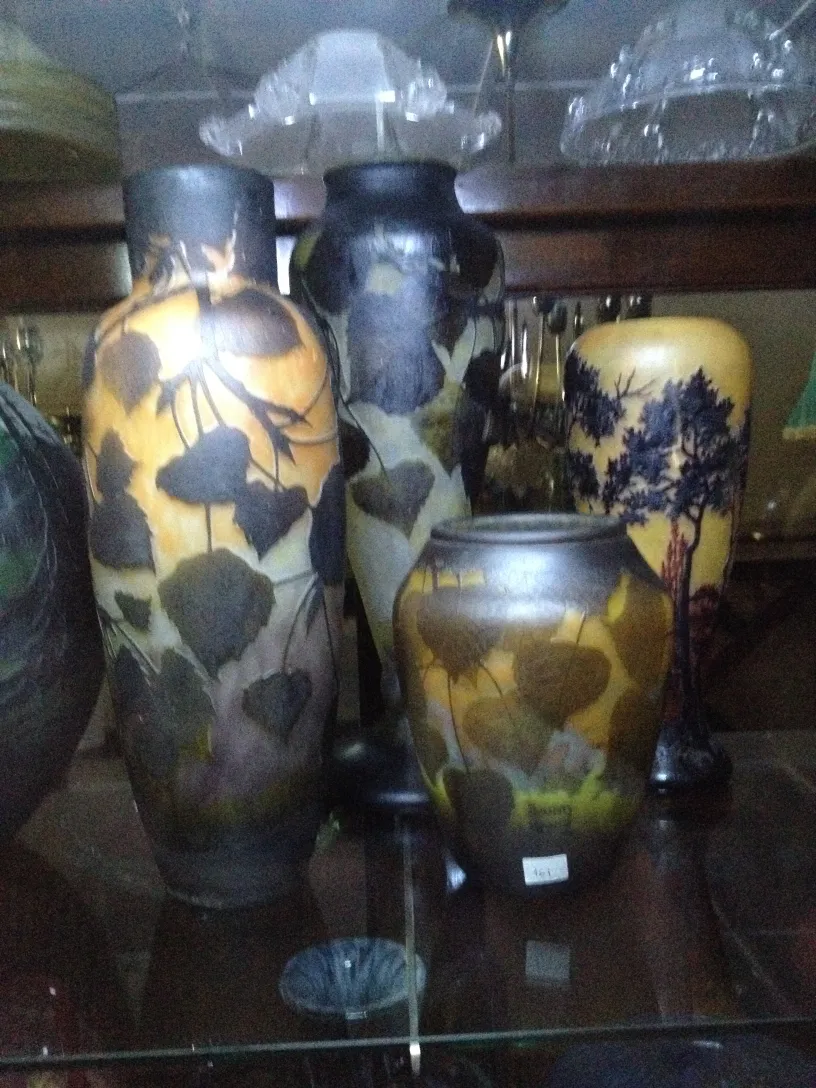 Collection of antique glass vases with artistic designs, dark background.